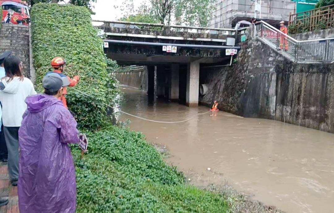 广州一男子在河道边钓鱼遇强降雨,水位瞬间升高,6名消防员用绳子搭通道把他拉上岸